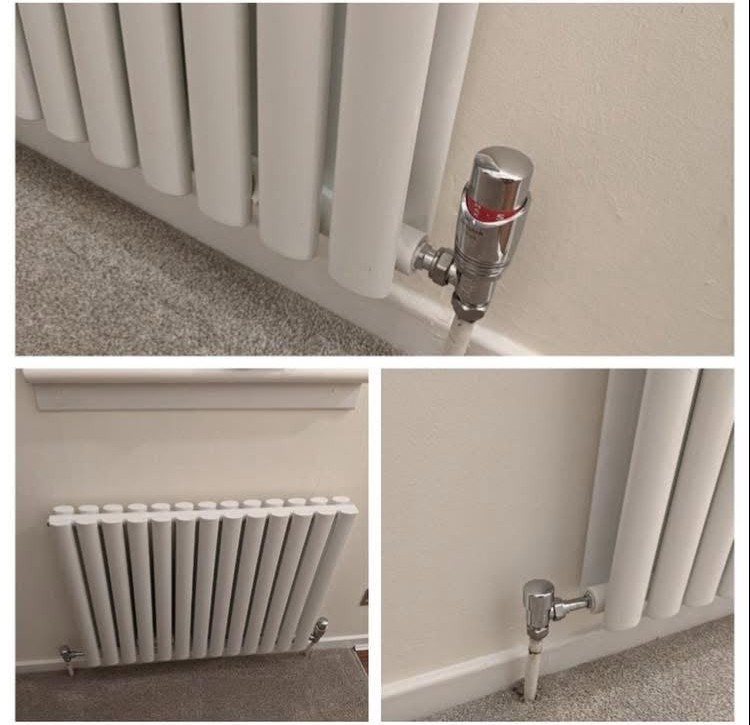 Close up of a white designer radiator installation showing thermostatic radiator valves and pipe connections
