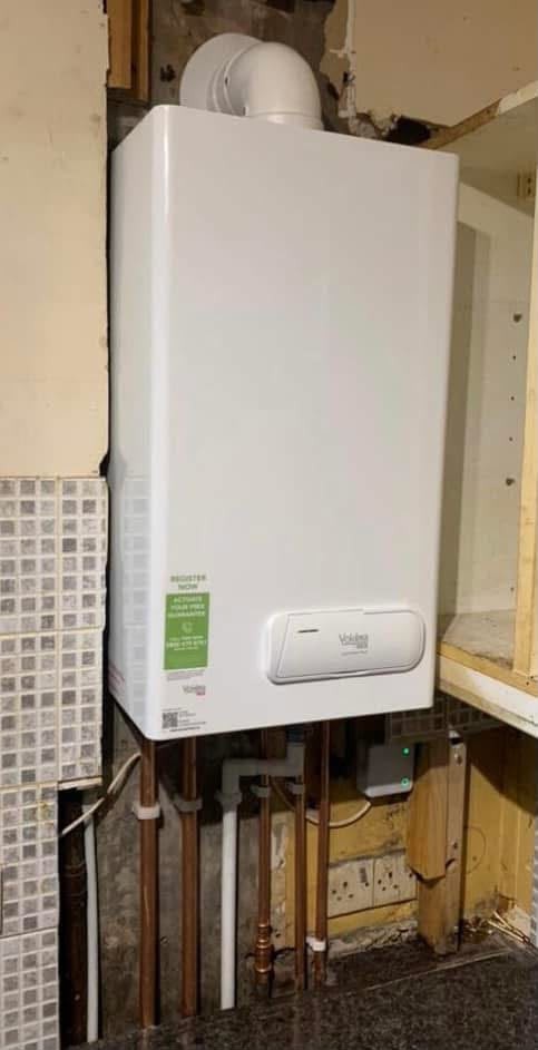 Wall mounted gas combi boiler installed above a worktop with tidy pipework and flue